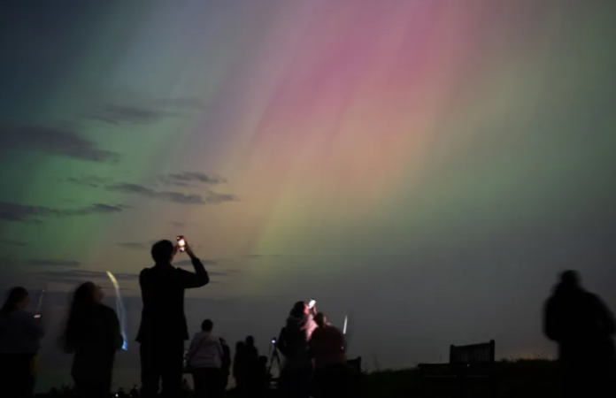 Spectators visit St Mary's Lighthouse in Whitley Bay in England to see the Aurora Borealis, commonly known as the northern lights